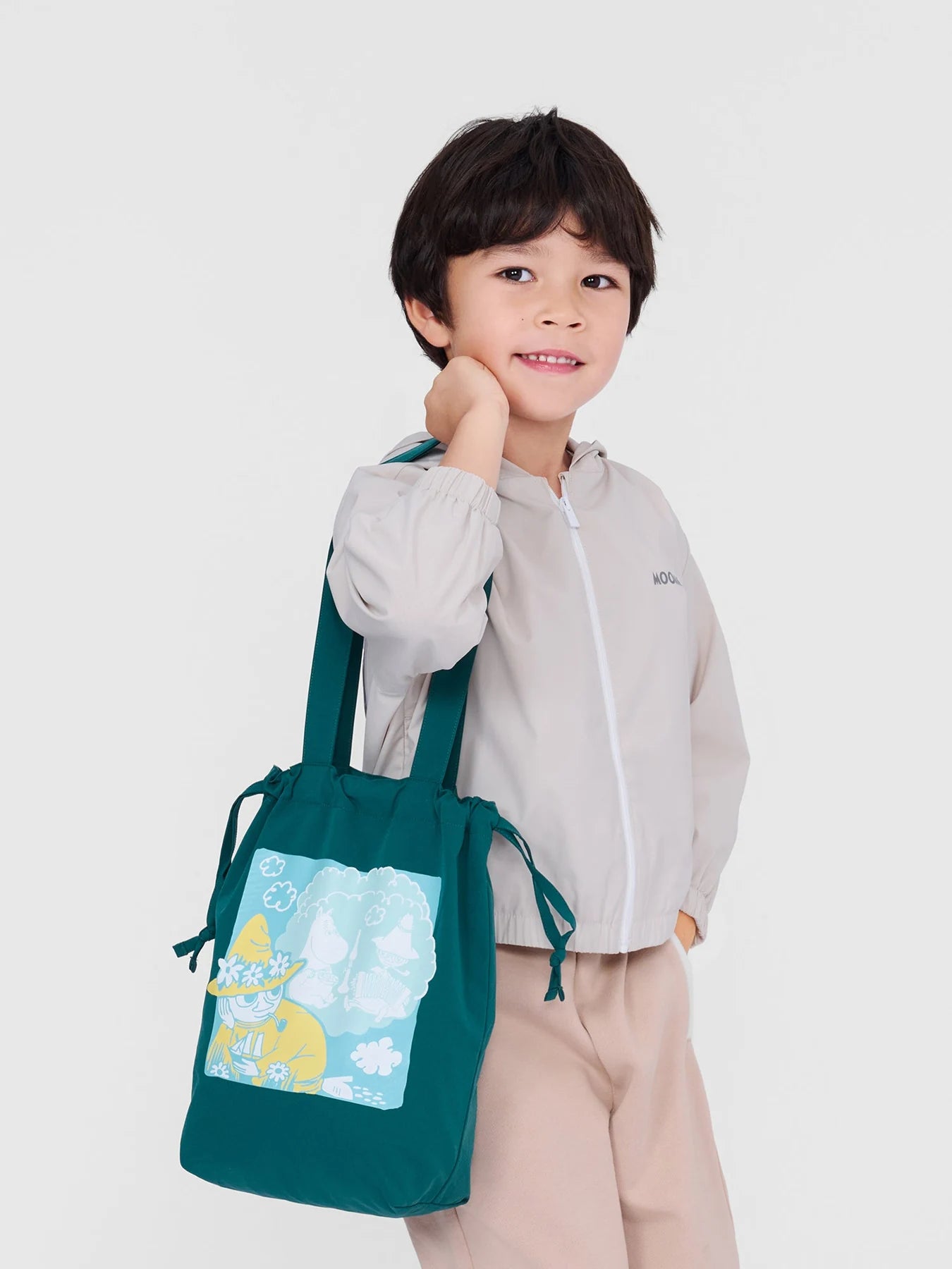 Boy carrying a green Snufkin tote with the ivory Stinky jacket.