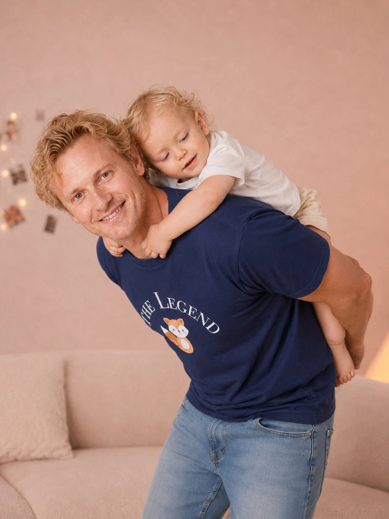 Father wearing The Legend navy tee with a child on his back.