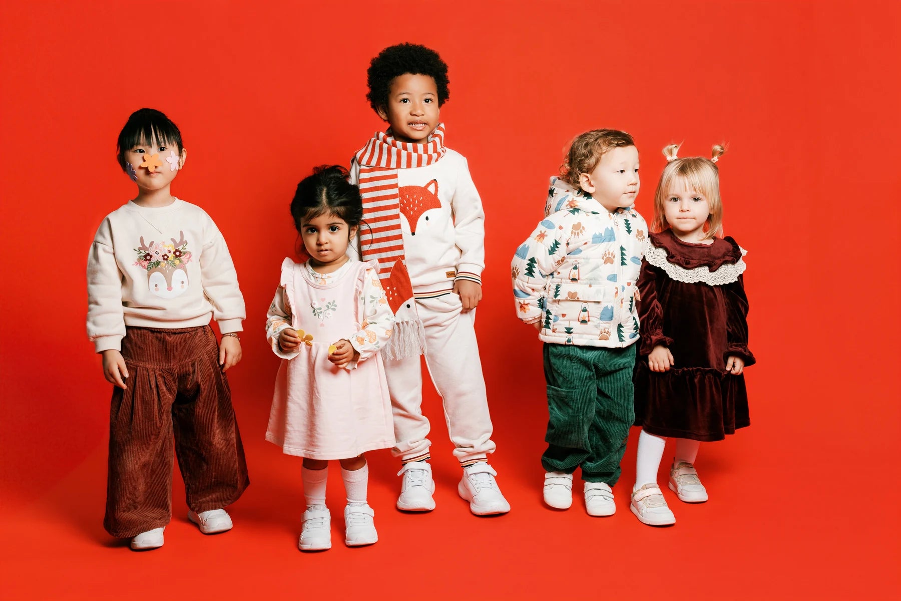 Five children standing together on the red Face of Vauva 2025 set