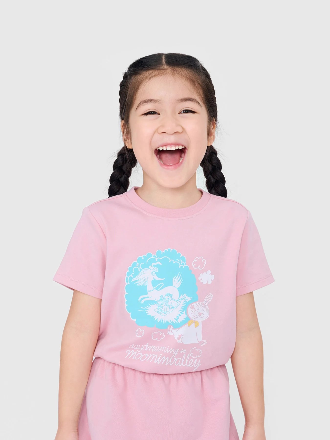 Girl laughing in a pink Little My graphic T-shirt from the Daydream collection.