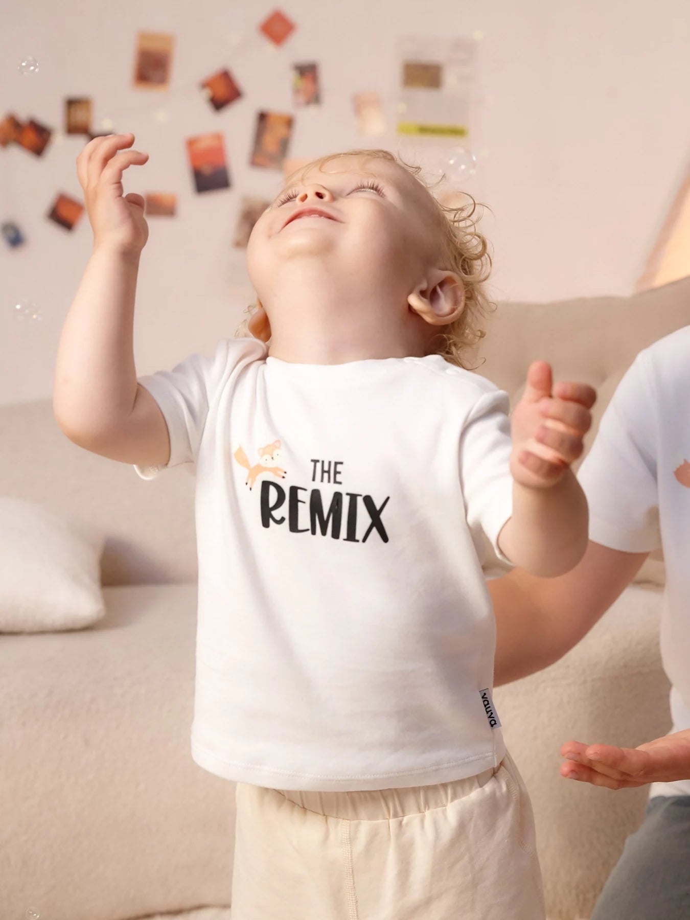 Child wearing the white The Remix graphic tee.