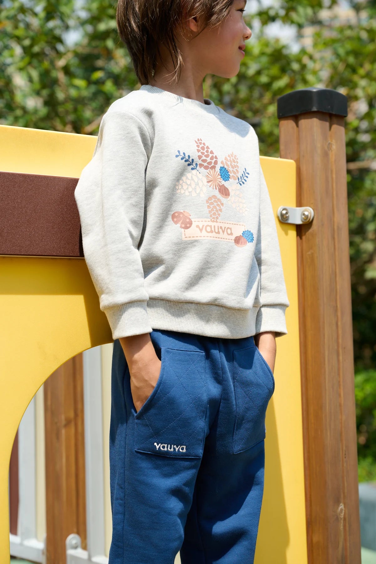A closer view of navy joggers paired with a grey printed sweatshirt at the playground.