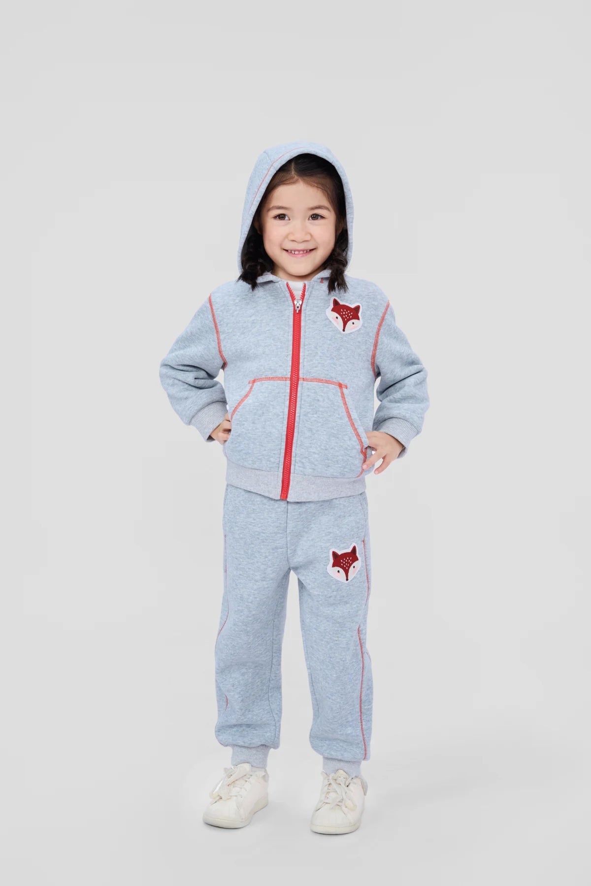 Girl wearing the grey fox patch zip jacket and matching joggers.