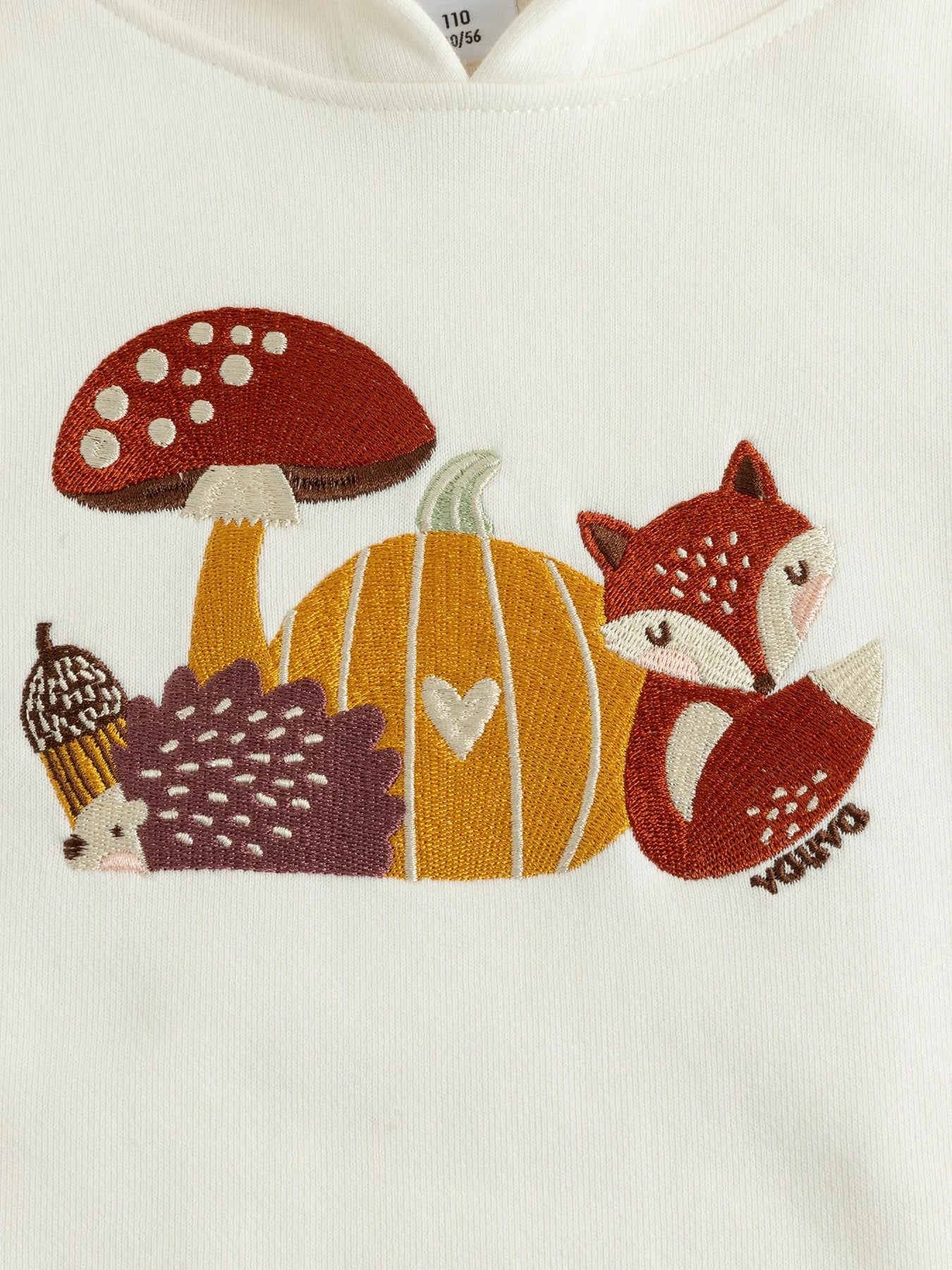 Woodland embroidery on the white hoodie.