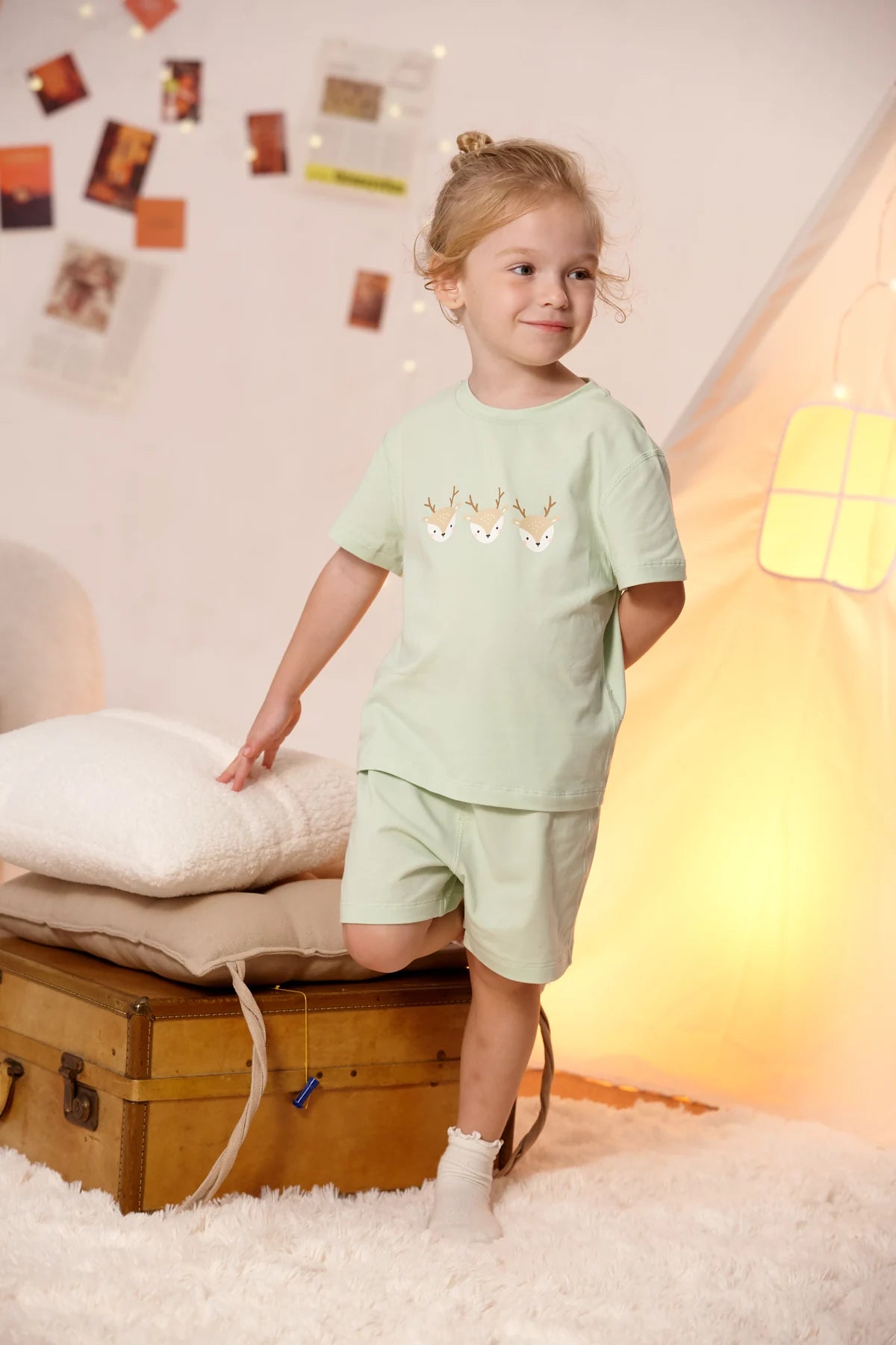 A child in the green deer T-shirt and coordinating shorts.