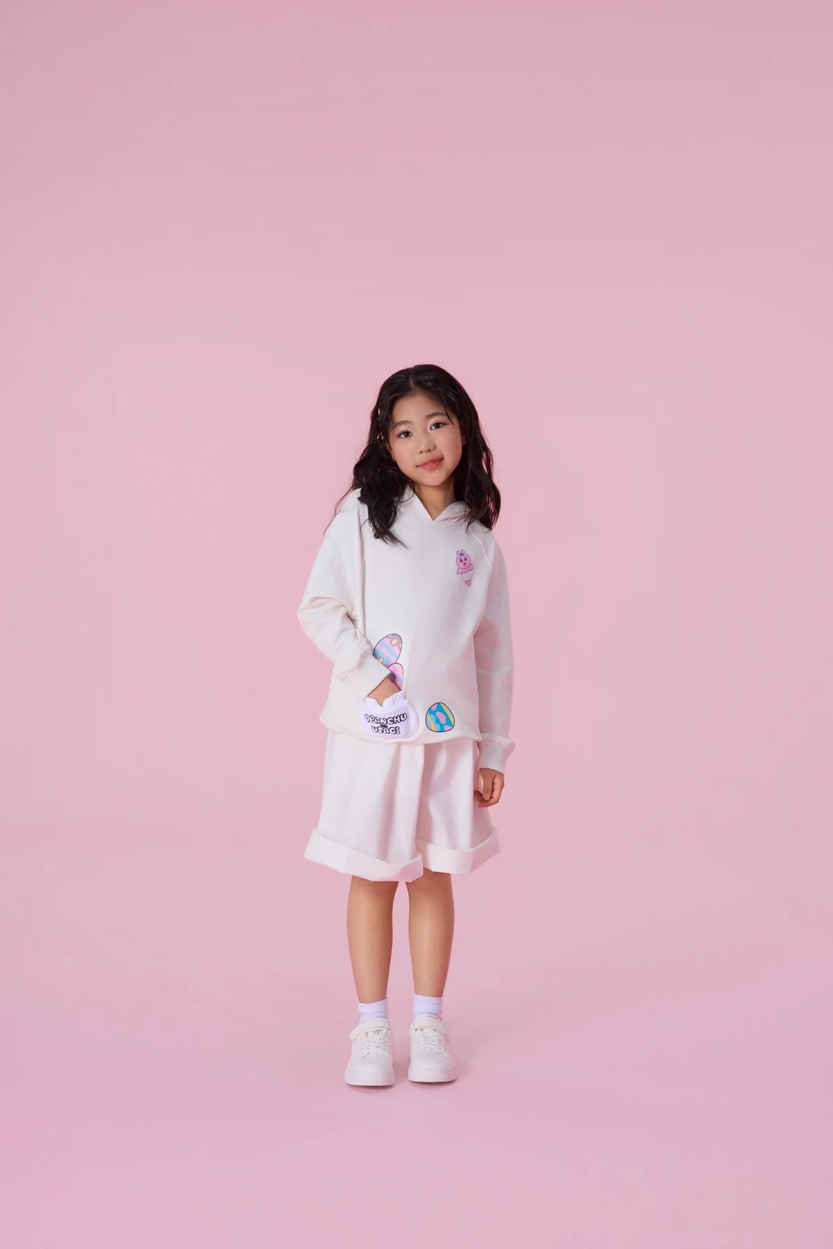 The white pocket sweatshirt gives the egg-and-bunny artwork another way to play.