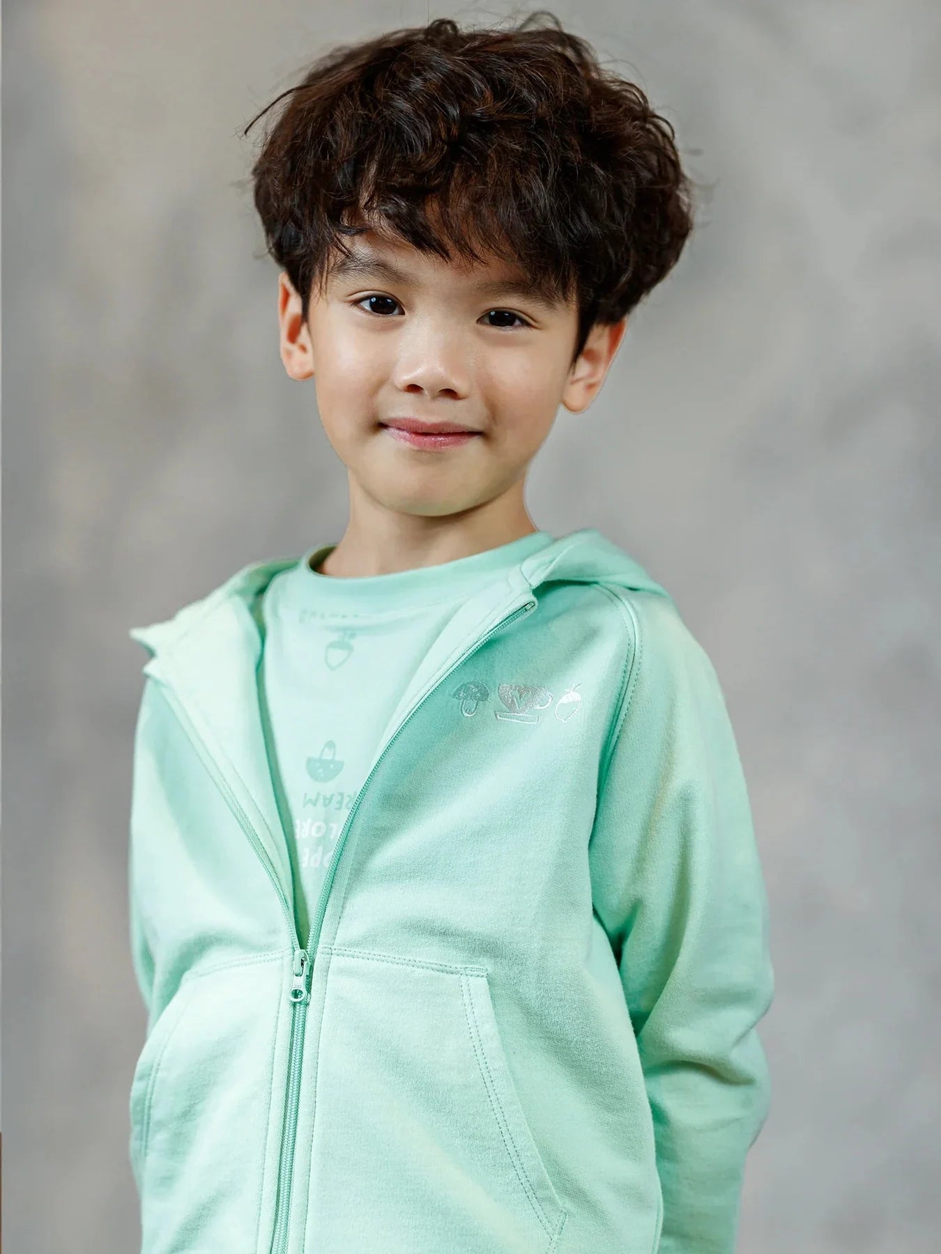 Child wearing a mint BBNS zip-up layer.