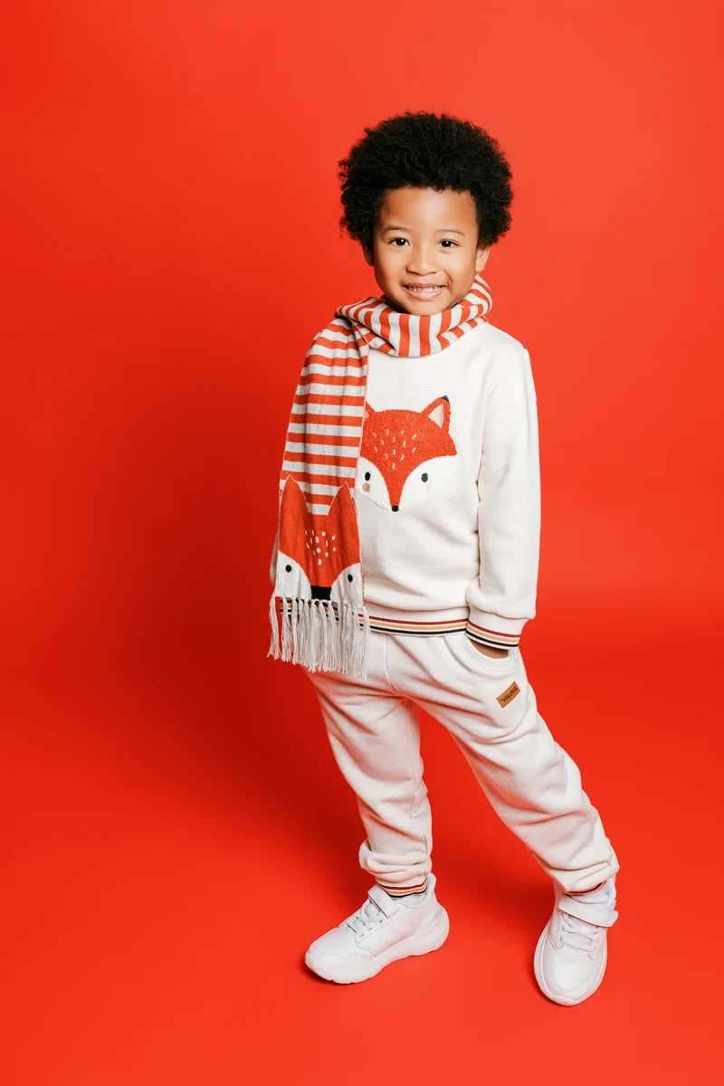 A smiling child in a striped top and fox-print outfit. Face of Vauva 2025.
