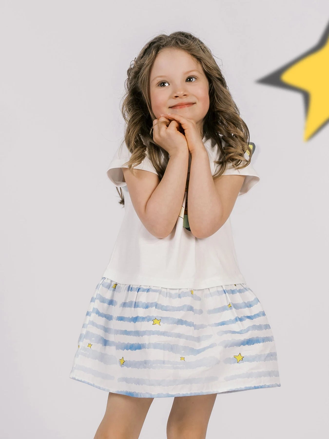 Girl with her hands under her chin wearing the two-tone Little Prince dress.