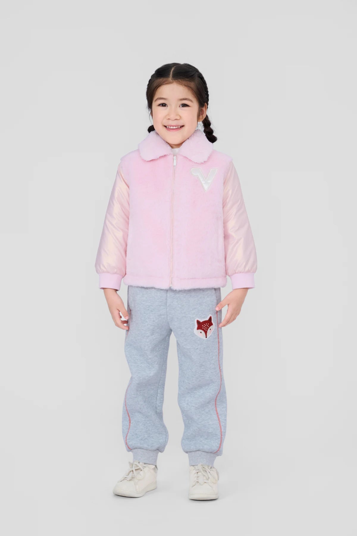 Girl in the pink plush jacket and grey fox patch joggers.