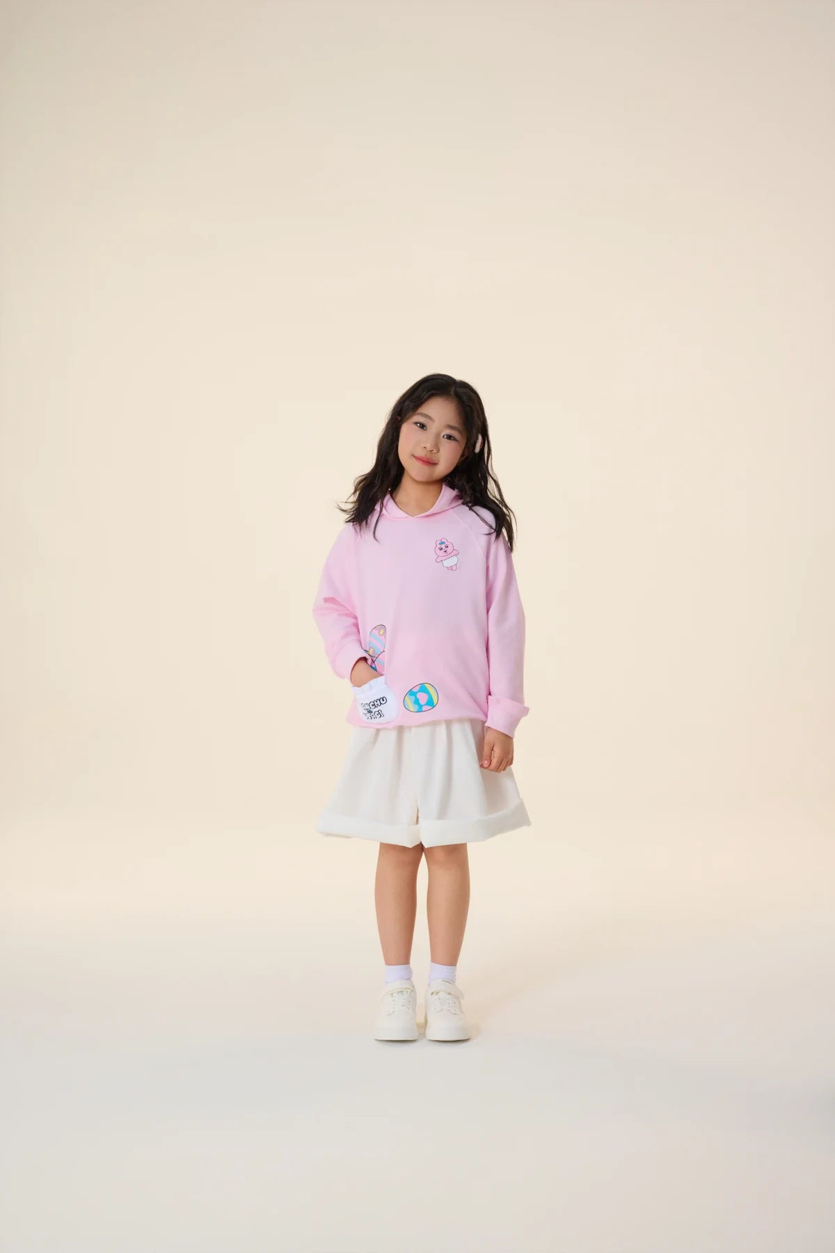 A pink hooded sweatshirt with printed patch pockets holds its own little surprises.