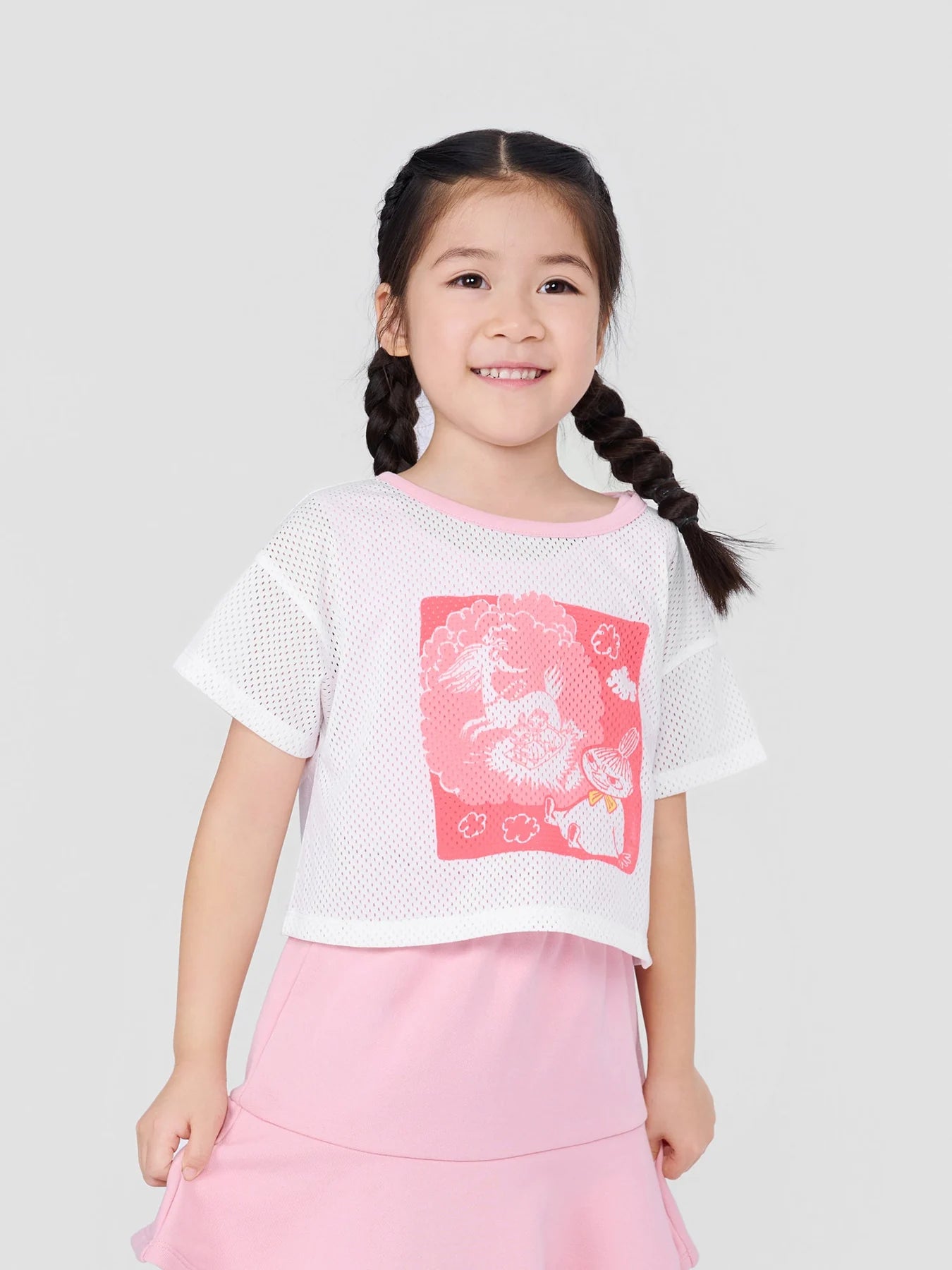 Girl wearing the Little My mesh T-shirt and pink inner tank top, with a styling skirt.