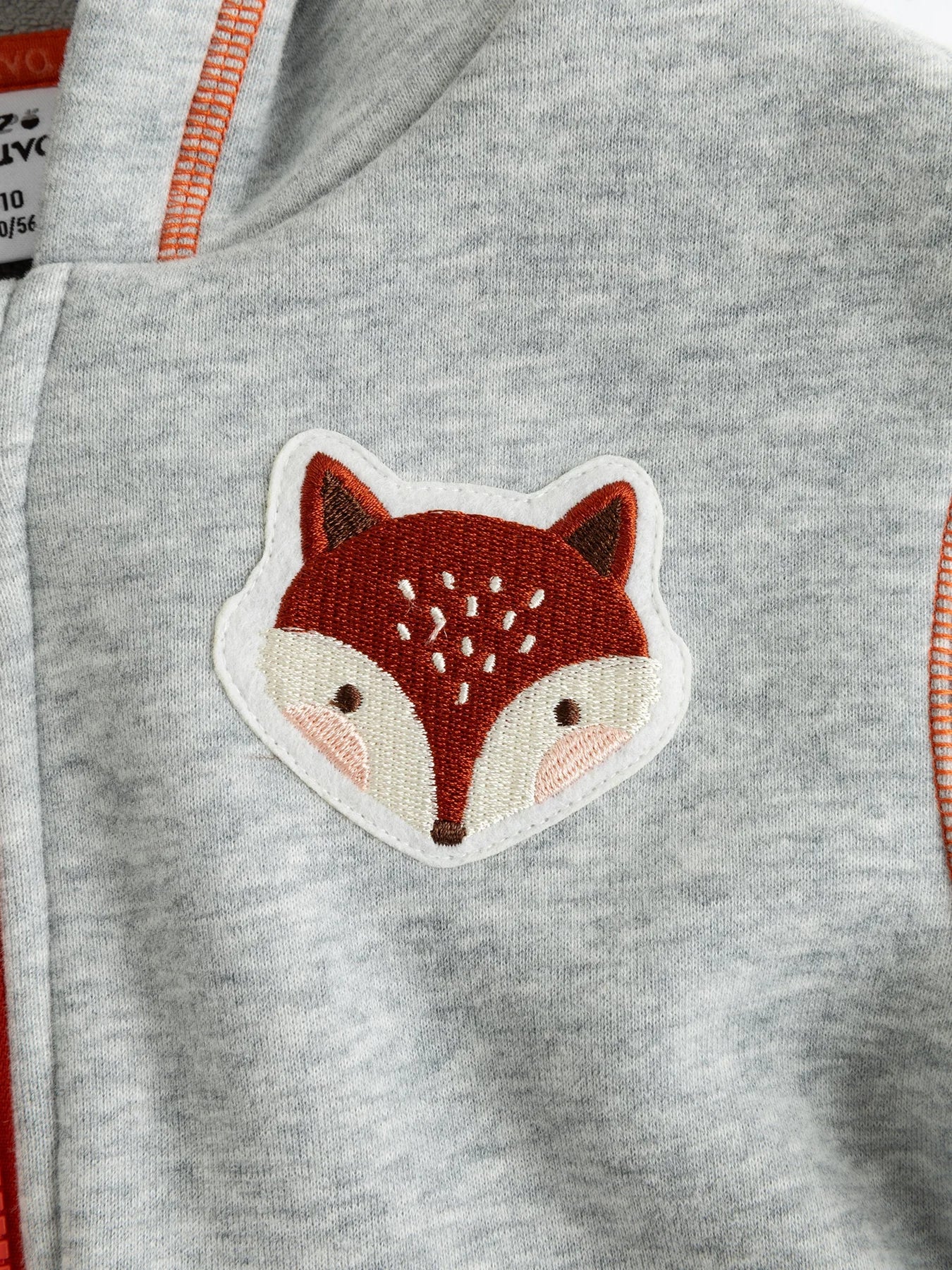 The fox patch detail on the grey zip-up.
