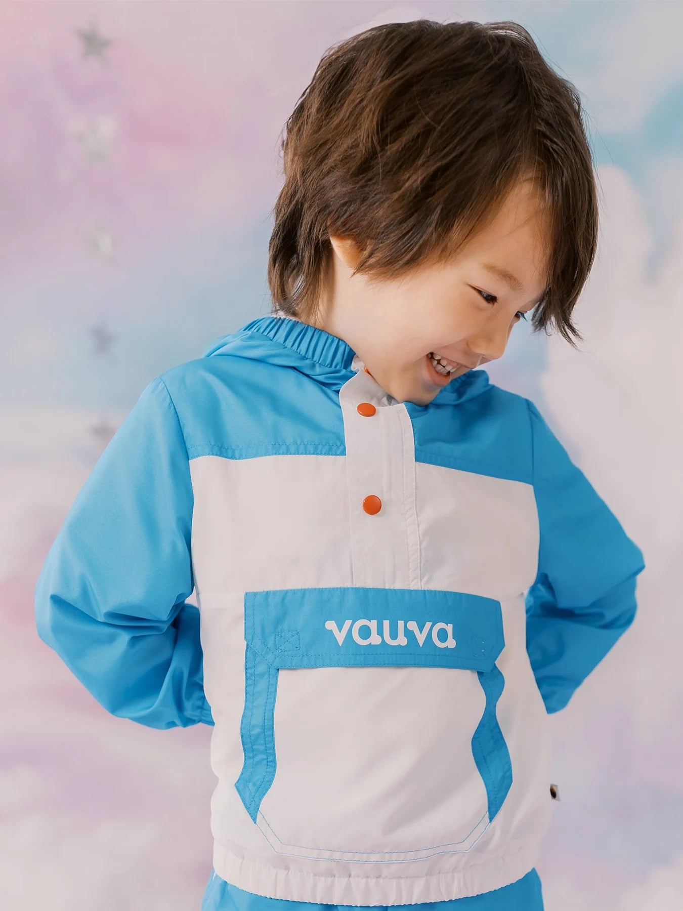 Child wearing the blue colour block pullover windbreaker and blue sports shorts.