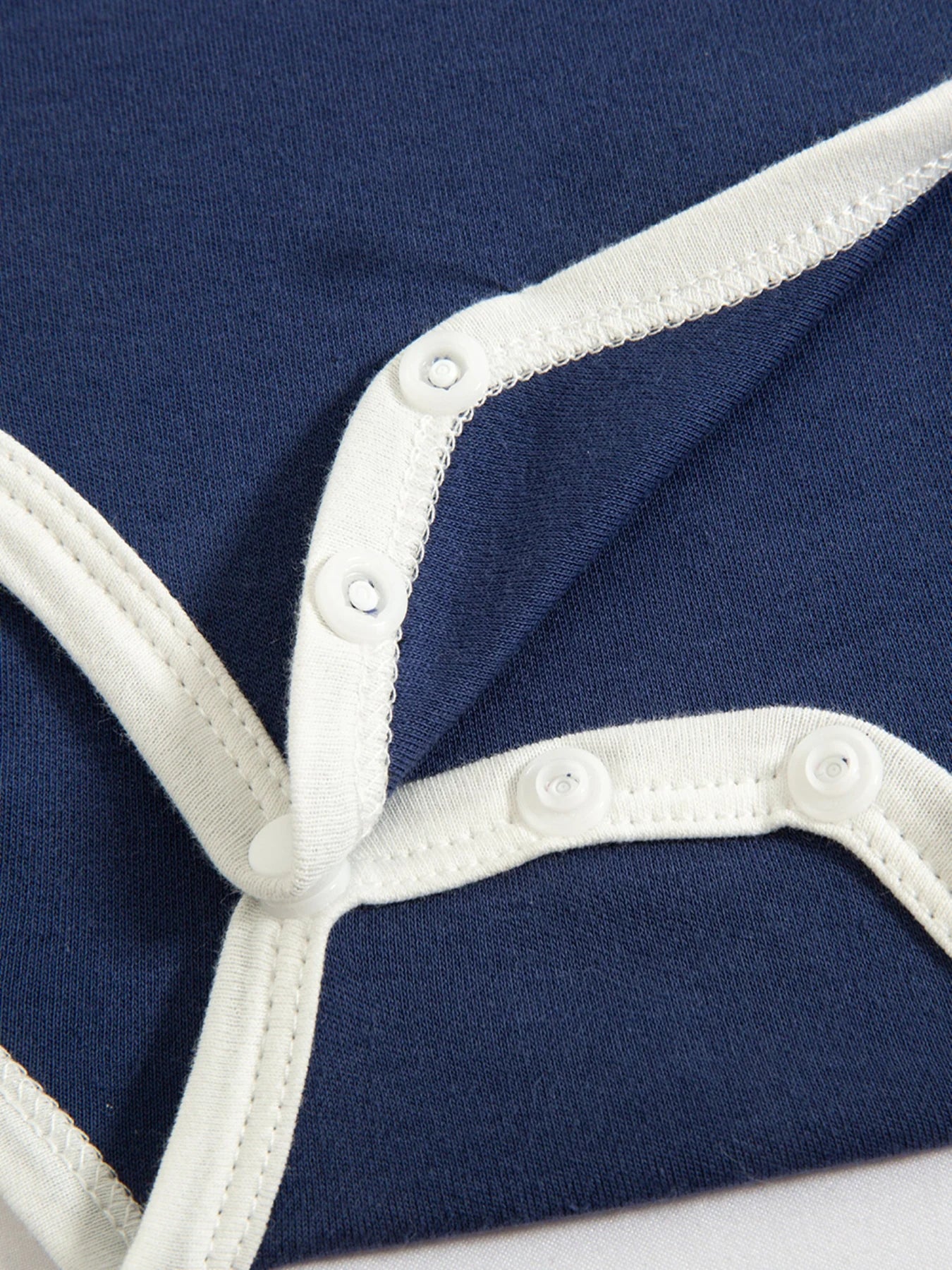 The baby bodysuit’s coordinating striped trim.