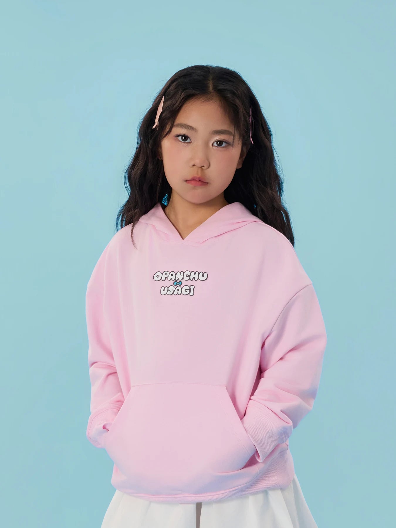 Close portrait of a girl wearing the pink bunny-ear hooded sweatshirt.