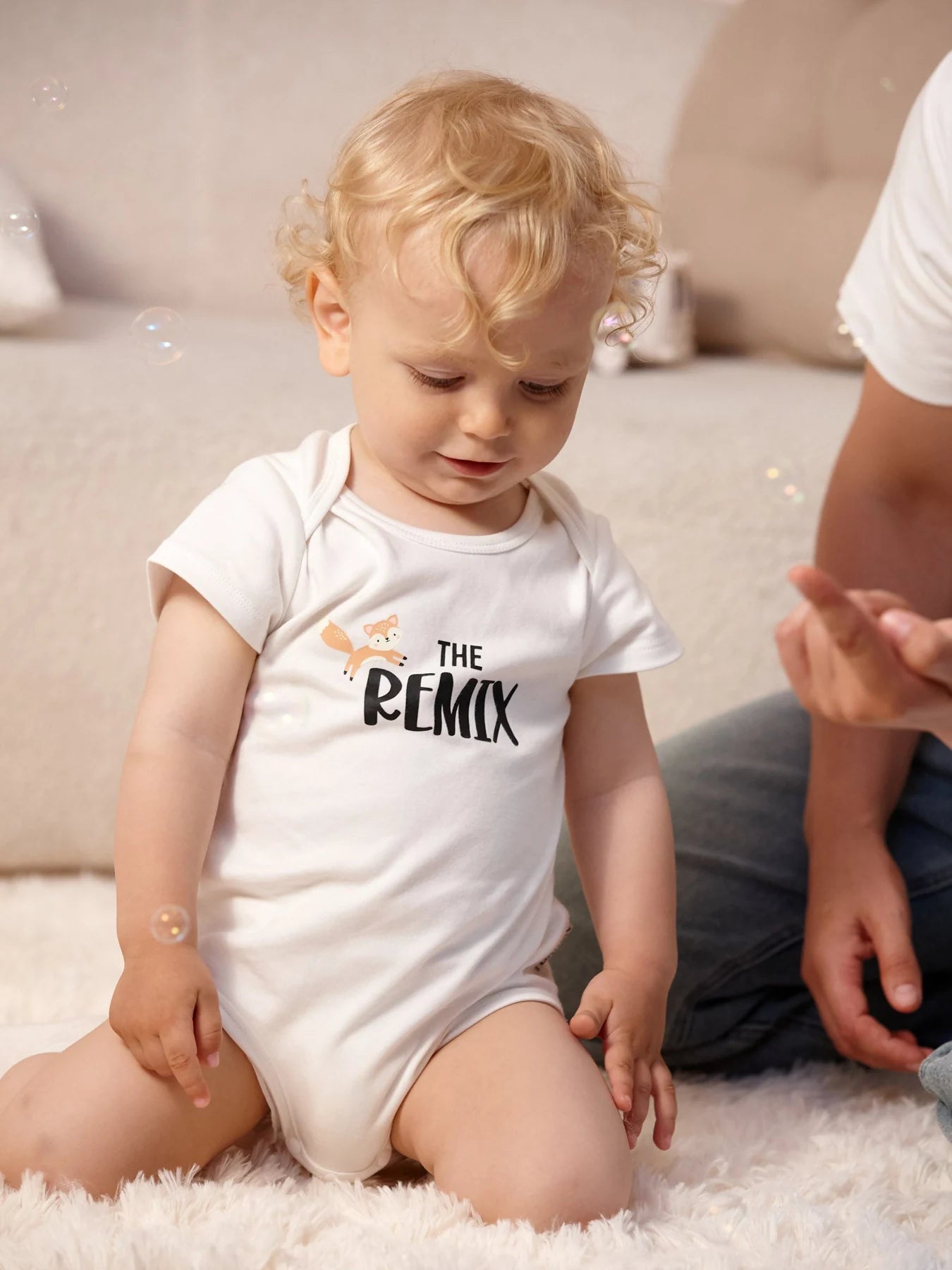 Baby wearing the white The Remix fox graphic bodysuit.