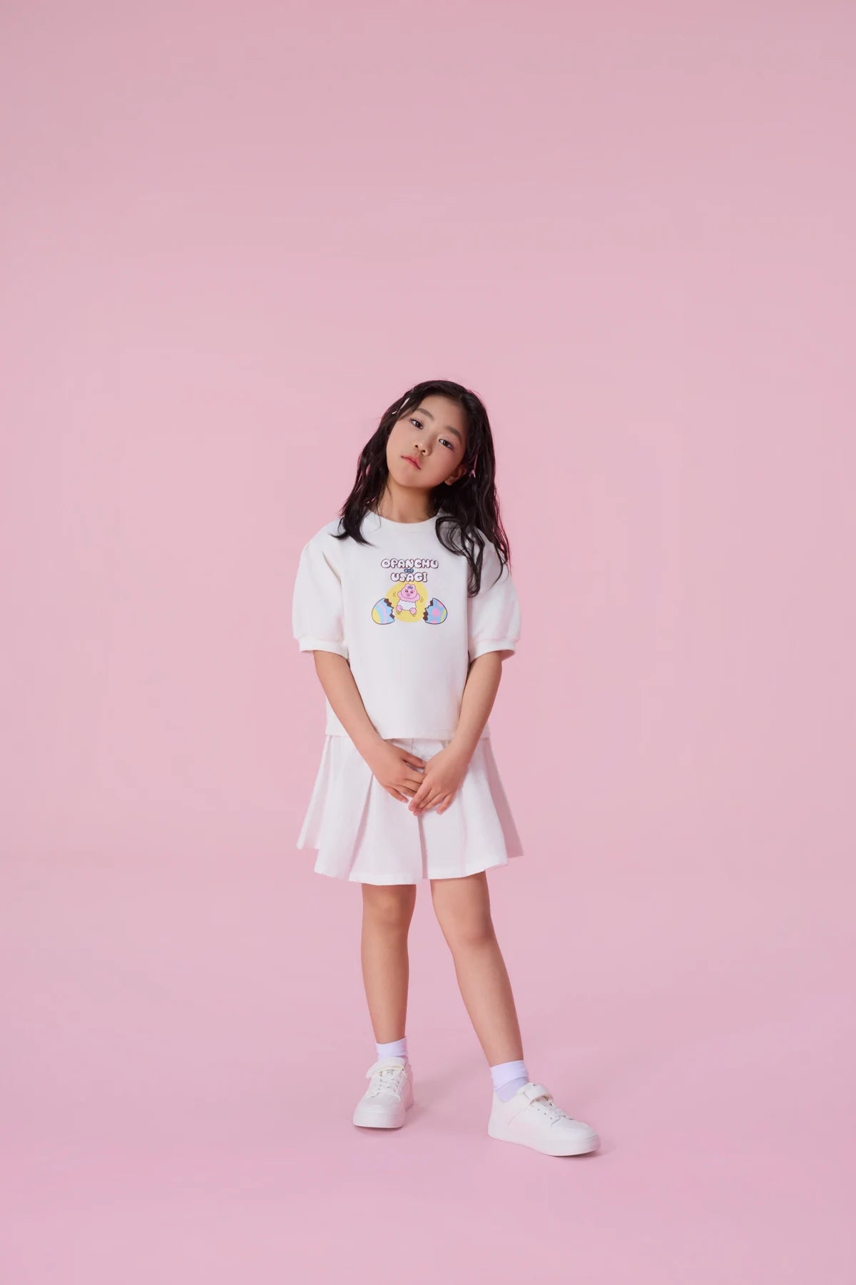 The white egg-print tee brings the same playful character into a lighter colour.