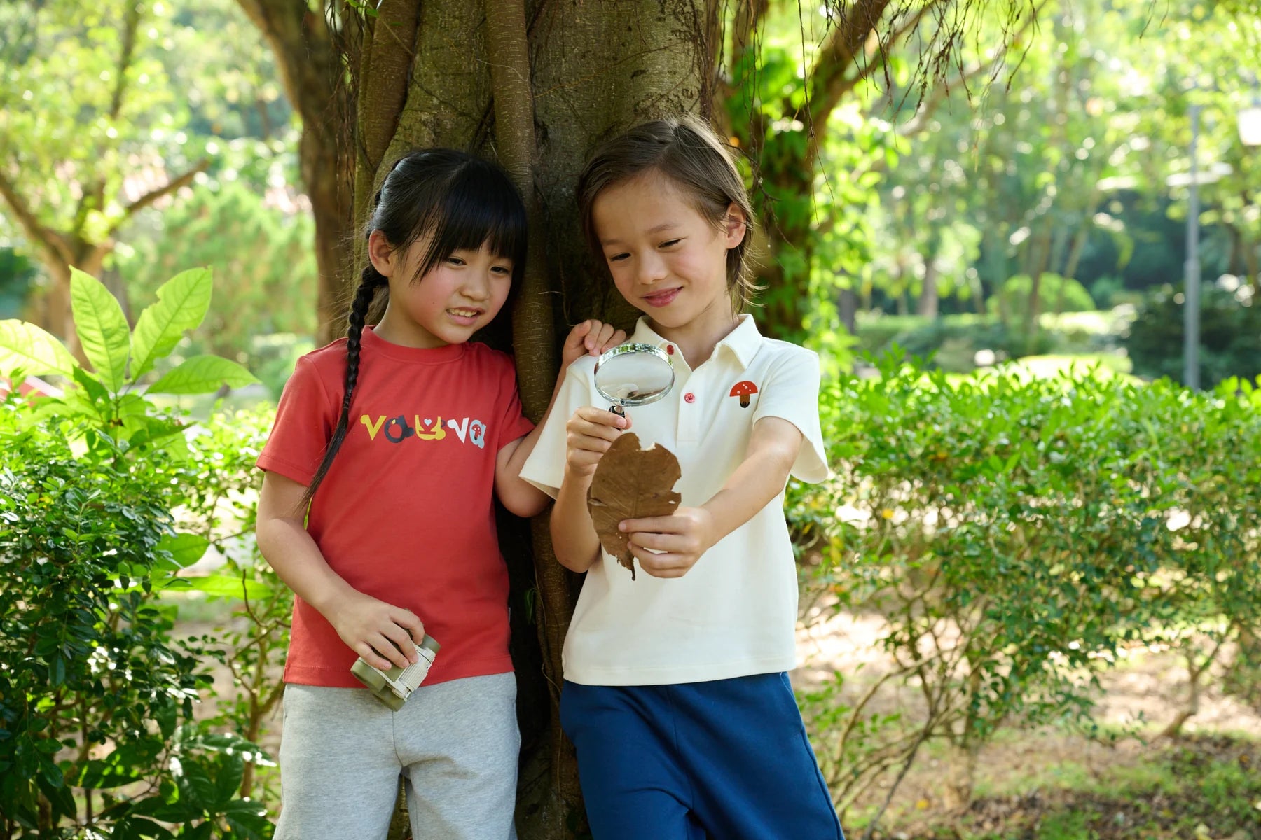 Two children drawing together under the trees in Vauva FW26.